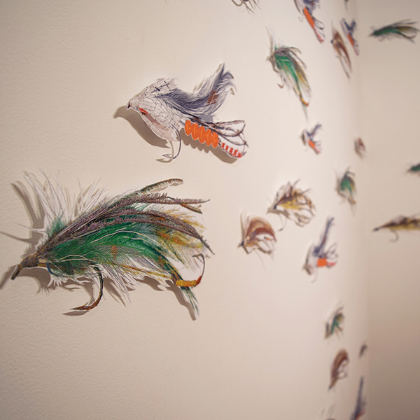 numerous 17" long digital illustrations of fishing lures, cut out and mounted on the wall. Link to Inheritance & Passed Down.