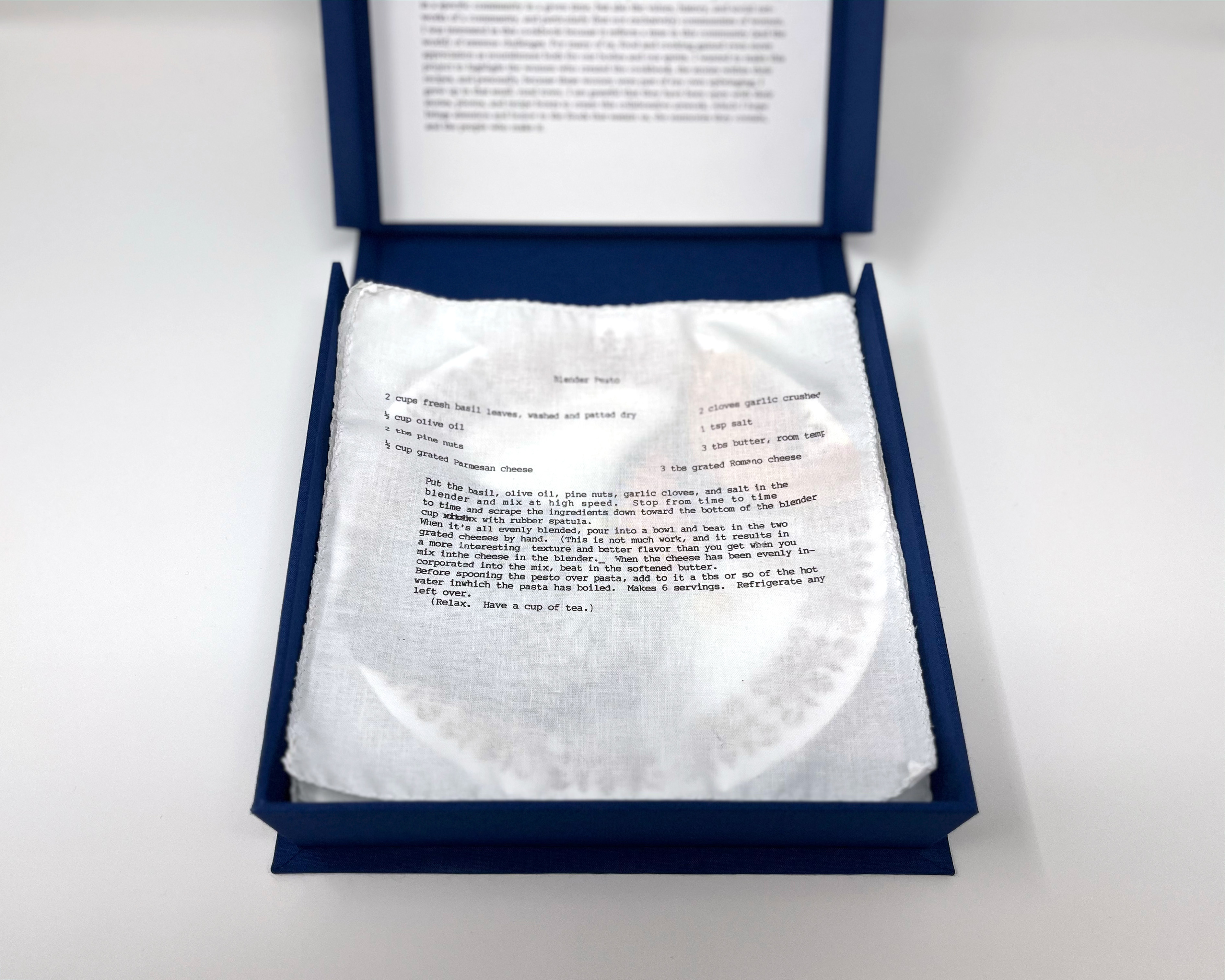 box open showing fabric liner underneath plate #2, printed with a Blender Pesto recipe. Text in paragraphs following. 