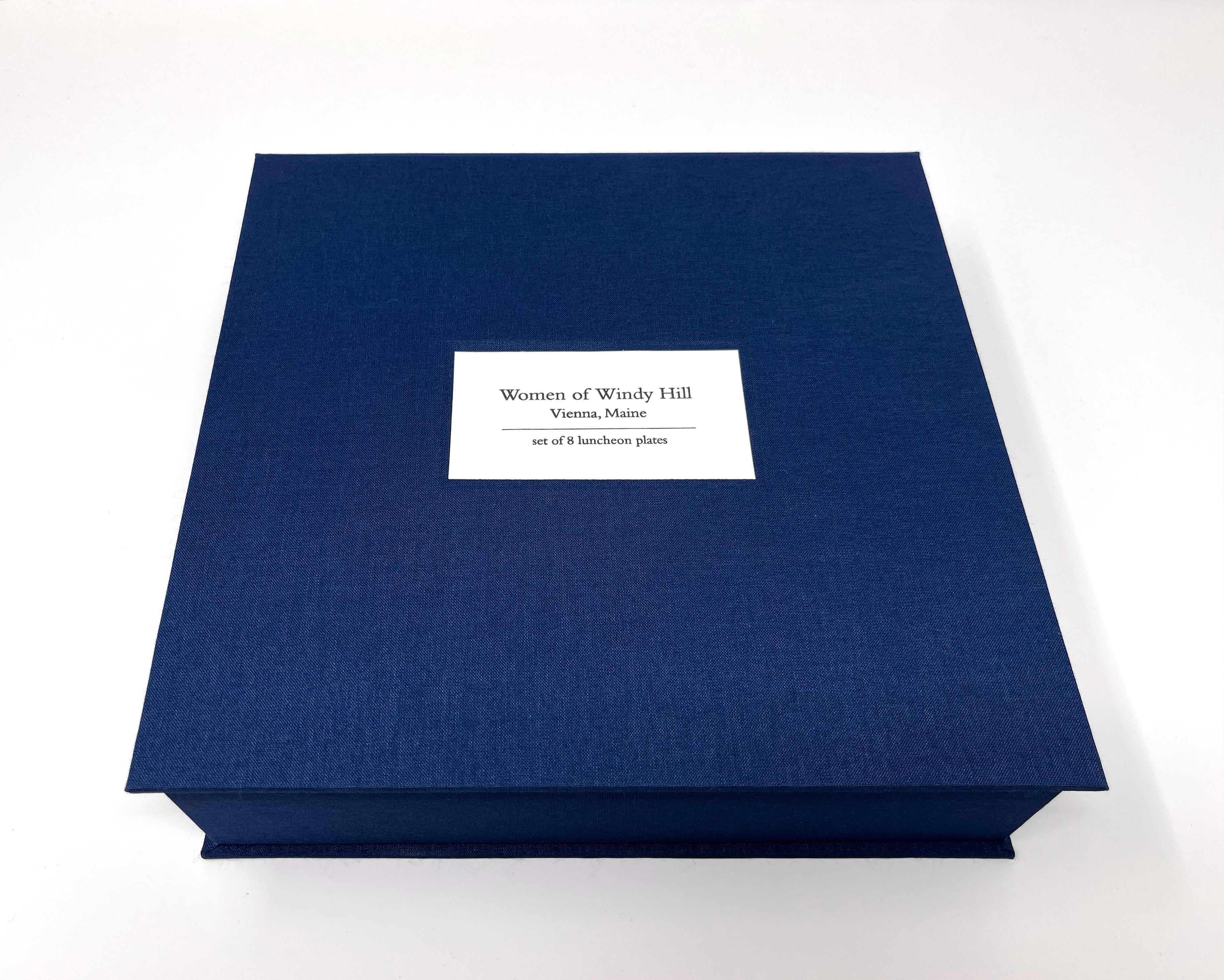 closed clamshell box with title that reads: Women of Windy Hill, Vienna, Maine, set of 8 luncheon plates
