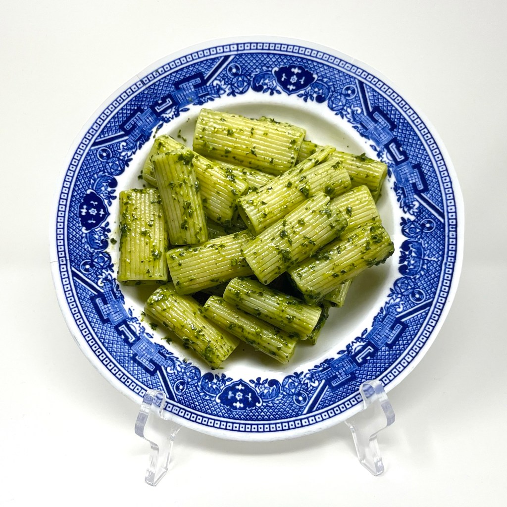 inkjet printed plate with a photo of pesto and pasta on a blue patterned plate